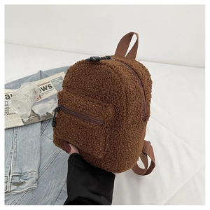 Detail of soft brown faux shearling mini backpack with dual zippers and textured fabric