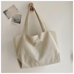 Detailed texture of off-white corduroy tote bag showing large capacity and soft fabric