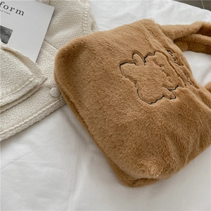 Sac cabas en peluche marron avec broderie lapin sur fond de tricot blanc pour un style cosy