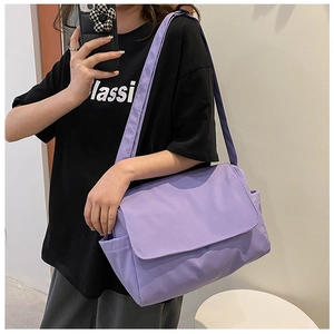 Close-up of a large purple Oxford cloth crossbody bag with wide shoulder strap