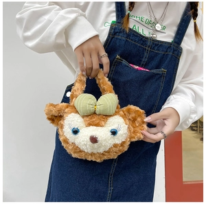 Detail of soft plush ShellieMay character crossbody bag with green bow on model