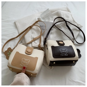 Detailed view of bucket bag bottom with protective gold metal studs and PU leather texture