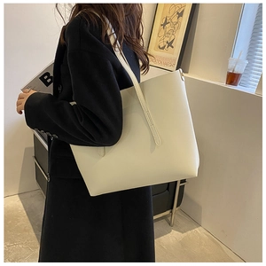 Minimalist beige tote bag shown in a lifestyle scene with soft faux leather texture