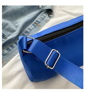 Détail de la bandoulière large réglable et boucle en métal sur le sac nylon bleu