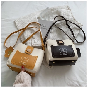 Detailed view of bucket bags showing bottom gold metal feet and cute bear graphics