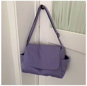 Detail view of purple waterproof oxford messenger bag with adjustable wide strap and flap cover