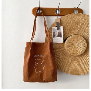 Dettaglio borsa tote in velluto a coste marrone con ricamo orso e scritta Beat Beat
