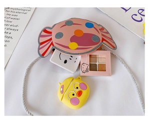 Détail du sac bandoulière rose en forme de bonbon avec sangle argentée et rangement