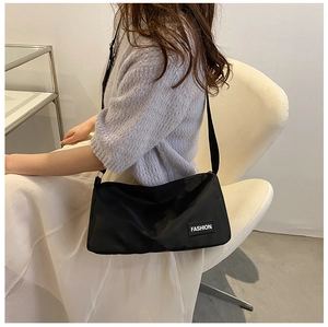 Détail du sac à bandoulière noir avec étiquette Fashion sur la sangle de l'épaule