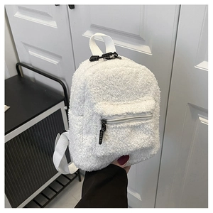 Close-up of white fuzzy sherpa mini backpack with zip pocket and webbing handle
