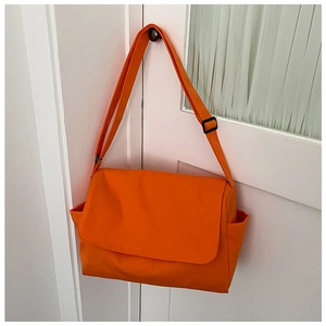 Detail of orange oxford cloth messenger bag with adjustable strap and side pocket