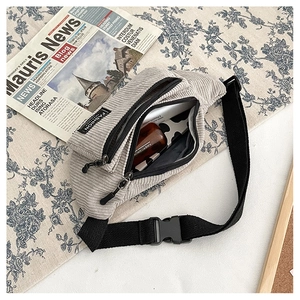Detailed top view of light grey corduroy waist bag with multiple zipper compartments
