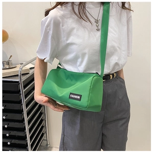 Détail du sac bandoulière en nylon vert avec étiquette 'FASHION' noire élégante