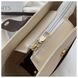 Detail of premium cream bucket bag with metal zipper and magnetic buckle closure