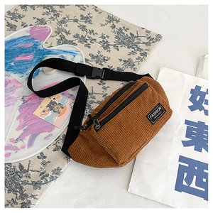 Detail view of brown corduroy waist bag showing texture and FASHION INSTINCT logo label