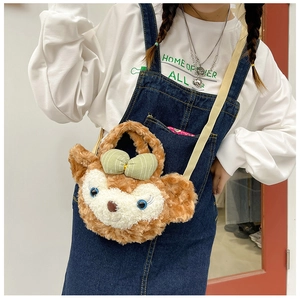Detail of cute plush crossbody bag with bear character and pink bow on denim dress