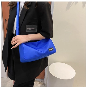 Détail de la bandoulière en nylon bleu avec étiquette de mode et sangle réglable sur modèle