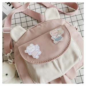 Detail of pink and white crossbody bag with cute bear ears and plush charm