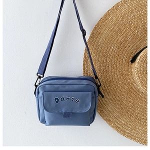 Detail of blue nylon crossbody bag with DANCE print and adjustable strap for daily use