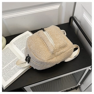 Detail view of beige faux shearling mini backpack with zipper and canvas straps