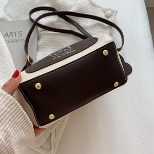 Contrast bucket bag with cartoon bear print and golden metal feet on a white background