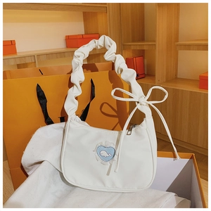 Detail der weißen Sichel-Schultertasche mit Spitze, Herz-Patch und Falten-Griff