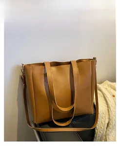 Detail view of large brown tote bag showing pebbled leather texture and strap
