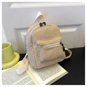 Close-up of cream white fleece mini backpack with fuzzy teddy texture and zipper detail