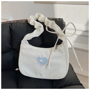 Detailansicht der weißen Schultertasche mit Falten, Herz-Patch und Wal-Stickerei