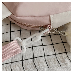 Close-up of pink crossbody bag with durable plastic hooks and high-density woven strap
