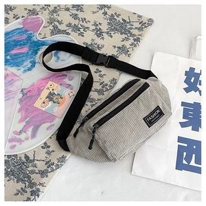 Detail of grey corduroy chest bag with double zipper pockets and fashion label