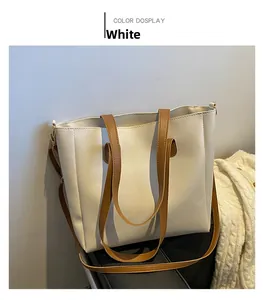 Detail of soft white PU leather tote bag with contrasting brown handles and shoulder strap