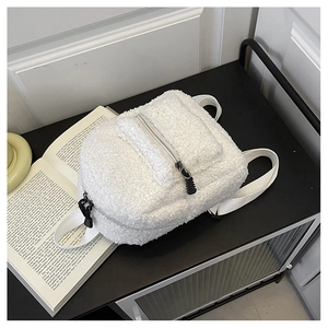 Detail of soft white faux shearling mini backpack texture and black dual zipper hardware