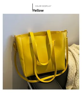 Detail of yellow minimalist tote bag showing vegan leather texture and adjustable strap