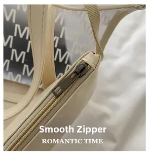 Detailed macro view of the smooth metal zipper and textured PU leather of the handbag