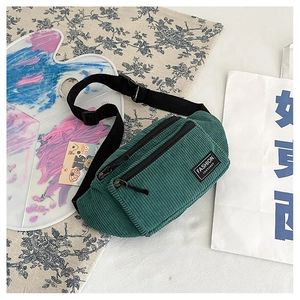 Close-up of a dark green corduroy chest bag with adjustable strap and fashion label