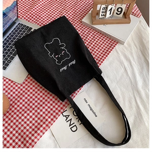 Dettaglio della borsa tote in velluto nero con ricamo di orsetto bianco e scritta Bear Bear