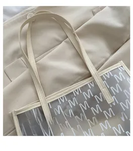 Close-up of translucent frosted PU tote bag with elegant white M-pattern and cream straps