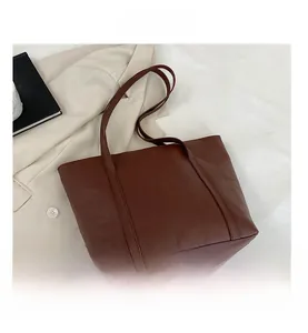 Close-up of brown quilted faux leather tote bag with elegant rhombus pattern detailing
