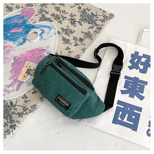 Detail of dark green corduroy waist bag showing texture and adjustable strap