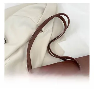 Detailed close-up of brown quilted leather tote bag strap and elegant sewing finish
