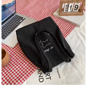 Dettaglio della borsa tote in velluto a coste nero con simpatico orso ricamato in bianco