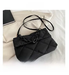 Detail view of large quilted black crossbody bag with chunky chain and nylon texture