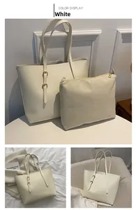 Detail view of off-white tote bag set with matching inner pouch and gold-tone hardware
