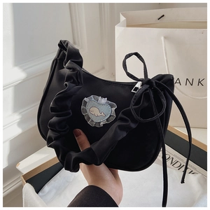 Detail einer schwarzen Segeltuch-Handtasche mit Rüschengriff und Wal-Herz-Spitzenapplikation