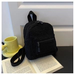 Detail of soft black faux shearling mini backpack with front pocket and metal zippers