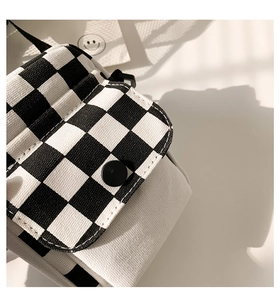 Detailaufnahme der schwarz-weiß karierten Canvas-Tasche mit schwarzem mattem Druckknopf
