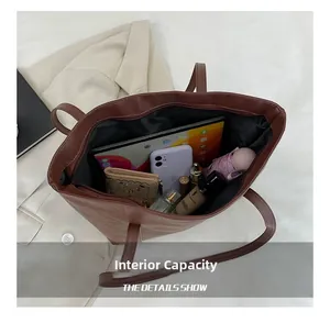 Macro view of brown quilted tote bag showing large capacity for laptop and cosmetics