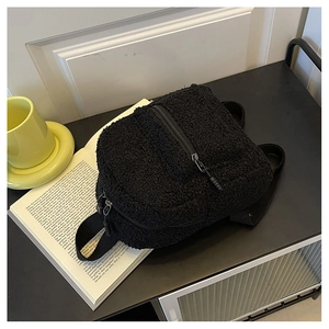 Detail of black faux shearling mini backpack showing fluffy texture and zippers
