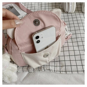 Detail of pink and white cat-ear crossbody bag interior showing phone storage space